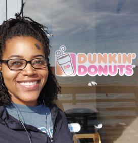 Dr. Angie Jasper smiling next to a Dunkin' Donuts window